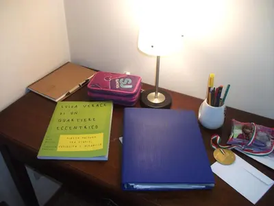a desk with a laptop and a book on it at Magnifico Cozy Apartment 400m da metroB in Rome