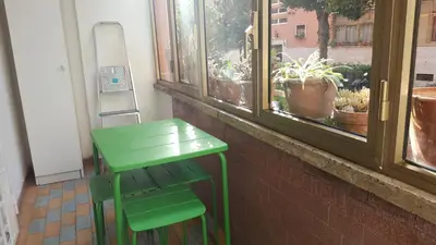 a green chair and a green table in front of a window at C'è posto per te in Rome
