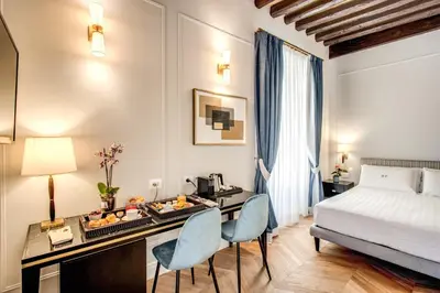 a hotel room with a bed and a tray of fruit on a desk at Babuino Palace&Suites in Rome