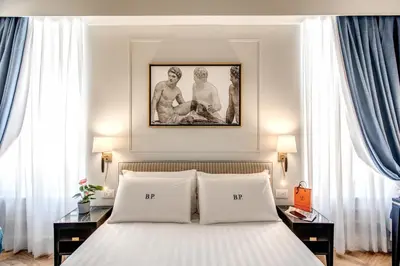 a bedroom with a bed with a picture above it at Babuino Palace&Suites in Rome