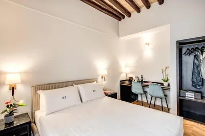 a bedroom with a bed and a desk and chairs at Babuino Palace&Suites in Rome