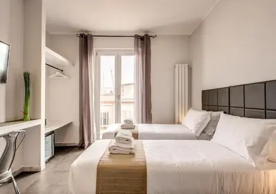 a hotel room with two beds and a couch at Floor 6 Boutique Rooms by DOT Suites in Rome