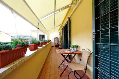 a balcony with a table and chairs and potted plants at Mecenate Charme Apartment in Rome