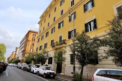 a yellow building with cars parked on the side of a street at Mecenate Charme Apartment in Rome