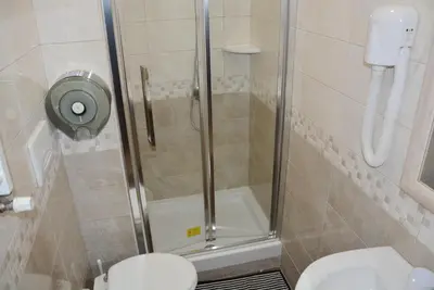 a shower with a glass door next to a toilet at Roma Carina in Rome