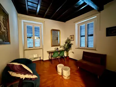a living room with a couch and a table and windows at House Maximo near Vatican in Rome
