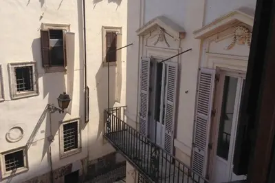 a white building with shuttered windows and a balcony at House Maximo near Vatican in Rome