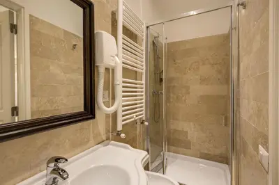 a bathroom with a shower and a toilet and a sink at Hotel Tito in Rome
