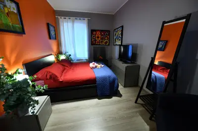 a bedroom with a bed with red sheets and a mirror at The Roman Residence in Rome
