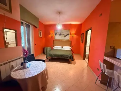 a bedroom with orange walls and a bed and a table at Suites Oliveri Viale Marconi in Rome