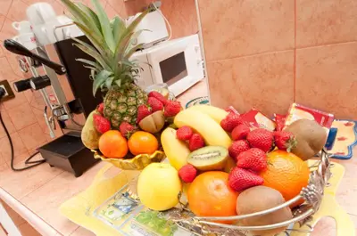 a bowl of fruit on a counter with a pineapple at Suites Oliveri Viale Marconi in Rome