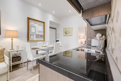a kitchen and dining room with a counter and a table at AS Vaticano Apartment in Rome