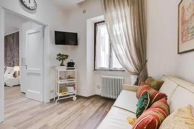a white living room with a couch and a window at AS Vaticano Apartment in Rome