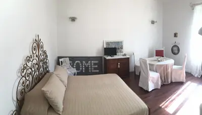 a bedroom with a bed and a table and a desk at Maru Apartment in Rome