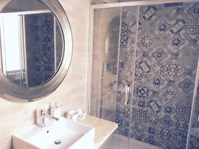 a bathroom with a shower and a sink and a mirror at Maru Apartment in Rome