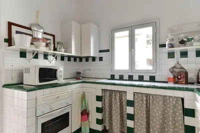 a kitchen with green and white tiles and a microwave at Maru Apartment in Rome