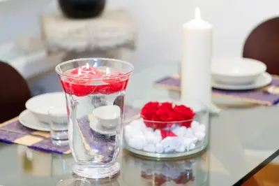 a glass vase with red and white marshmallows and red roses at Romanticasa Trastevere in Rome