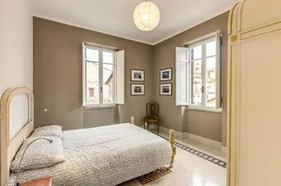 a bedroom with a bed and two windows at Monti Coliseum Apartment in Rome