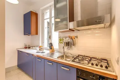 a kitchen with blue cabinets and a sink at Monti Coliseum Apartment in Rome