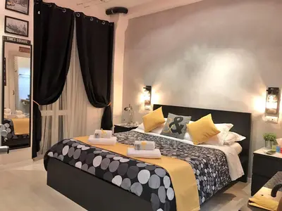 a bedroom with a large bed with black and yellow pillows at Moonlight Inn Guesthouse in Rome