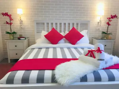 a bedroom with a bed with red and white pillows at Moonlight Inn Guesthouse in Rome