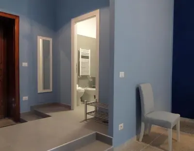 a bathroom with blue walls and a chair and a mirror at 325 Rooms ai Fori in Rome
