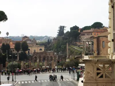 a group of people crossing a street in a city at 325 Rooms ai Fori in Rome