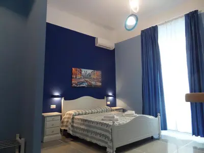 a bedroom with a bed and a blue wall at 325 Rooms ai Fori in Rome