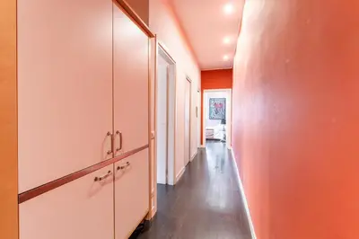 a hallway with orange walls and a long hallway at Atmosphera Trastevere, Glamour apartment in the center in Rome