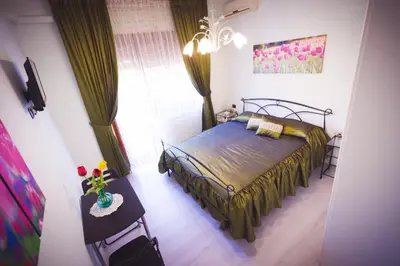 a bedroom with a bed and a vase of flowers on a table at Floreo Guest House in Rome