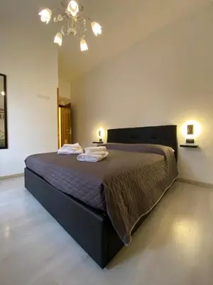 a bedroom with a large bed with a brown comforter at Floreo Guest House in Rome