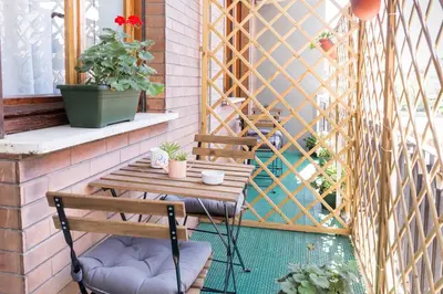a patio with a table and chairs on a balcony at Floreo Guest House in Rome