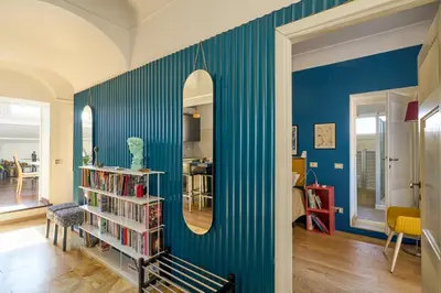 a room with a blue wall with a mirror at La Mia Casa in Campo di Fiori in Rome