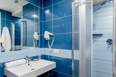 a blue bathroom with a sink and a shower at Rhome Accomodation in Rome