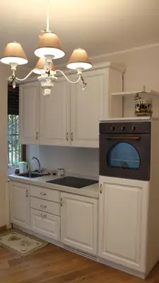 a kitchen with white cabinets and a black oven at La Cupola Suite in Rome