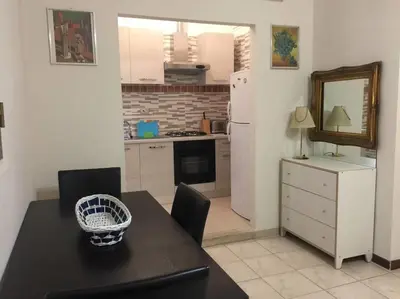 a kitchen with a black table and a white refrigerator at Lorenzo Magnifico Apartment in Rome