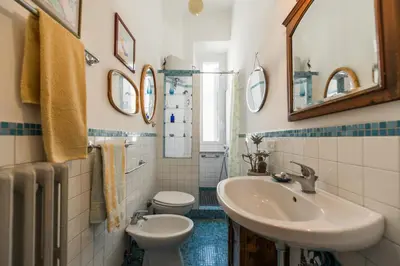 a bathroom with a sink and a toilet and mirror at Colosseo Holiday House in Rome