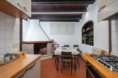 a kitchen with a table and a fireplace at Casa Trasteverina in Rome