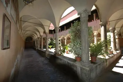 a hallway with arches and potted plants in a building at HISTORICAL CENTER ROME NAVONA AC 2 ROOMS HOLY DOOR VATICAN 5 MINUTES ON WALk in Rome
