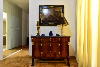 a dresser with a lamp and a painting on the wall at Elite Rome Apartments in Rome
