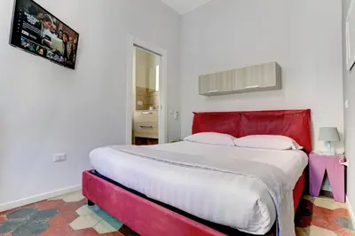 a bedroom with a large bed with a red headboard at Appartamento Santi Quattro - Colosseo in Rome