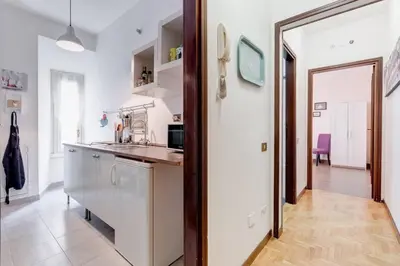 a kitchen with white walls and a doorway leading into a room at Saint Peter House Germanico in Rome