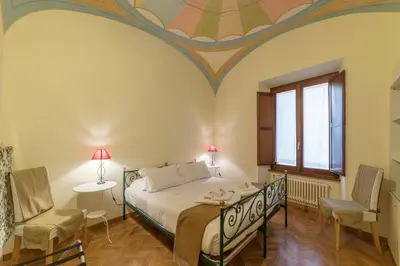 a bedroom with a bed and two chairs and a window at Casa Cornacchie - FromHometoRome in Rome