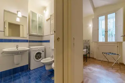 a bathroom with a toilet sink and a washing machine at Casa Cornacchie - FromHometoRome in Rome