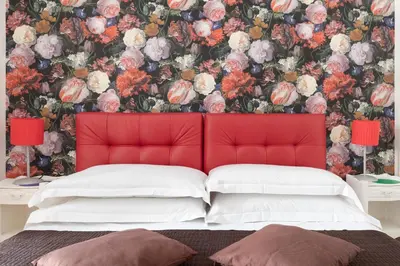 a bedroom with a red headboard and a floral wallpaper at Persia Collection Trevi in Rome