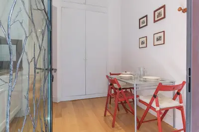 a dining room with a table and two red chairs at Domus Claudiae - FromHometoRome in Rome