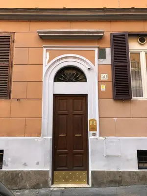 a brown door with an arch above it on a building at Restart Accommodations Farnesina in Rome