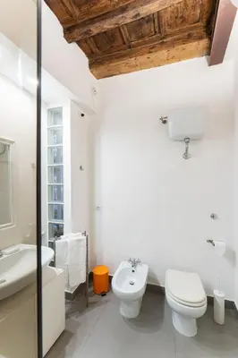 a white bathroom with a toilet and a sink at Your Home at Campo de' Fiori in Rome
