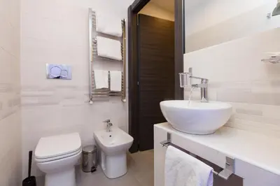 a white bathroom with a sink and a toilet at Domus Arena in Rome