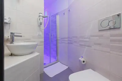 a bathroom with a sink and a shower with purple lighting at Domus Arena in Rome